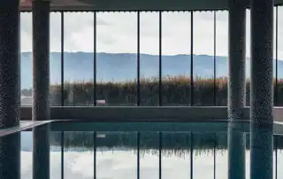Moderner Wellnessbereich mit grossen Fensterflächen und Blick auf die umliegende Landschaft.
