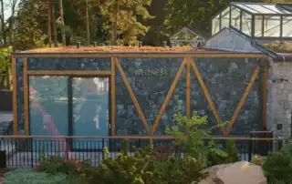 Modernes Wellnesszentrum mit Glasfassade, Naturstein und begrünter Dachfläche.