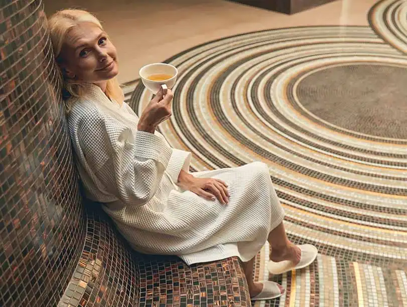 Frau entspannt mit einer Tasse Tee im Spa.