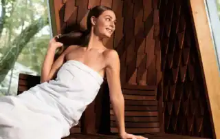 Entspannte Frau im Bademantel in einem modernen Spa mit natürlicher Holzgestaltung.