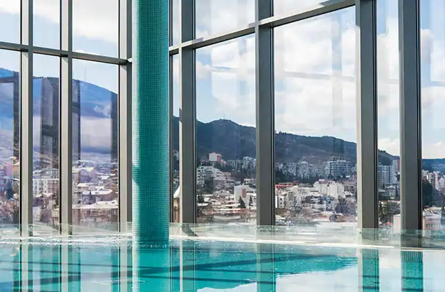 Moderner Wellnesspool mit grossen Panoramafenstern.