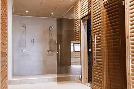 Moderner Saunabereich mit hochwertiger Holzverkleidung, Glasflächen und elegantem Innenraum.