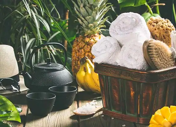 Wellnessarrangement mit Handtüchern und Pflanzen in natürlicher Umgebung.