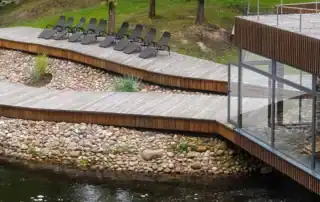 Wellnessanlage mit Holzsteg, Wasser und Natur.
