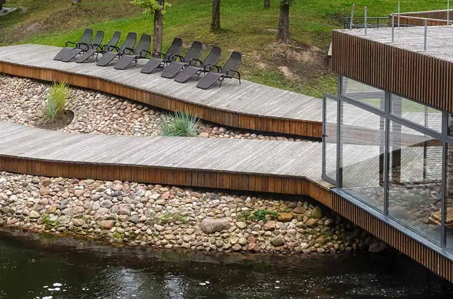 Wellnessanlage mit Holzsteg, Wasser und Natur.