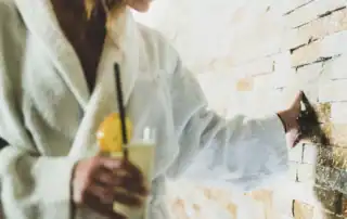Gast berührt Natursteinwand im Wellnessbereich.